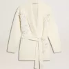 Cremefarbene Damenstrickjacke aus Baumwolle mit Blumenstickerei Cremefarbene Damenstrickjacke aus Baumwolle mit Blumenstickerei