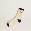 Cremefarbene gerippte Socken mit marineblauen Details und rotem Logo