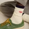Cremefarbene gerippte Socken mit marineblauen Details und rotem Logo