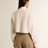 Cremefarbenes, kurz geschnittenes Sweatshirt für Damen aus Baumwolle mit Kristallen auf der Vorderseite Cremefarbenes, kurz geschnittenes Sweatshirt für Damen aus Baumwolle mit Kristallen auf der Vorderseite