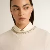 Cremefarbenes, kurz geschnittenes Sweatshirt für Damen aus Baumwolle mit Kristallen auf der Vorderseite Cremefarbenes, kurz geschnittenes Sweatshirt für Damen aus Baumwolle mit Kristallen auf der Vorderseite