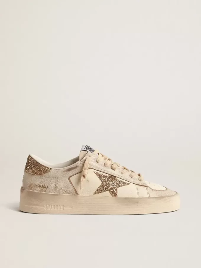 Damenmodell Stardan aus ecrufarbenem Nappaleder mit goldenem Glitzerstern und Fersenlasche Damenmodell Stardan aus ecrufarbenem Nappaleder mit goldenem Glitzerstern und Fersenlasche
