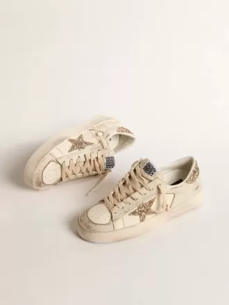 Damenmodell Stardan aus ecrufarbenem Nappaleder mit goldenem Glitzerstern und Fersenlasche Damenmodell Stardan aus ecrufarbenem Nappaleder mit goldenem Glitzerstern und Fersenlasche