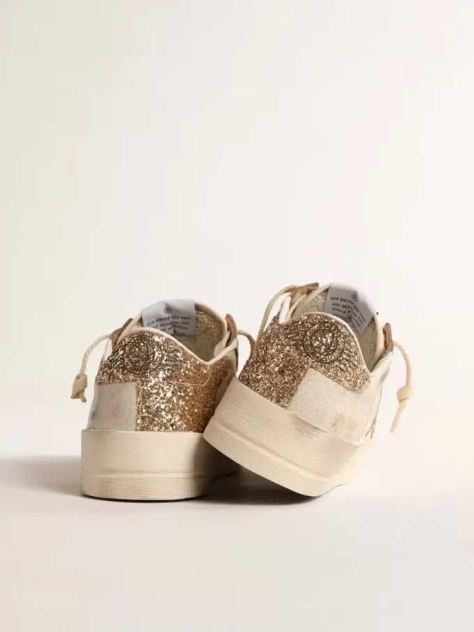Damenmodell Stardan aus ecrufarbenem Nappaleder mit goldenem Glitzerstern und Fersenlasche Damenmodell Stardan aus ecrufarbenem Nappaleder mit goldenem Glitzerstern und Fersenlasche