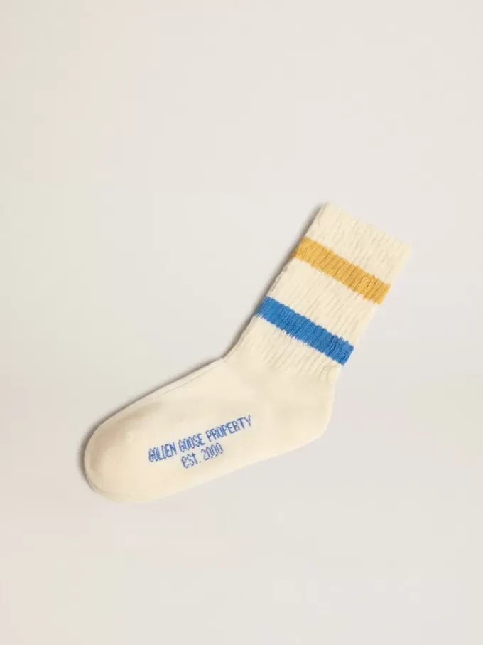 Getragene weiße Kindersocken mit Used-Details und zweifarbigen Streifen in leuchtendem Blau und Senfgelb Getragene weiße Kindersocken mit Used-Details und zweifarbigen Streifen in leuchtendem Blau und Senfgelb