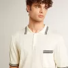 Herren-Polohemd in Used-Weiß mit blauen Rippbündchen Herren-Polohemd in Used-Weiß mit blauen Rippbündchen