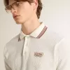 Herren-Poloshirt aus weißem, perforiertem Strick mit burgunderfarbenen Streifendetails Herren-Poloshirt aus weißem, perforiertem Strick mit burgunderfarbenen Streifendetails
