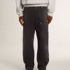 Herrenjeans aus schwarzem Baumwollstoff im Distressed-Look mit Aufnähern auf der Vorderseite Herrenjeans aus schwarzem Baumwollstoff im Distressed-Look mit Aufnähern auf der Vorderseite