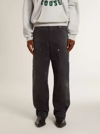 Herrenjeans aus schwarzem Baumwollstoff im Distressed-Look mit Aufnähern auf der Vorderseite Herrenjeans aus schwarzem Baumwollstoff im Distressed-Look mit Aufnähern auf der Vorderseite