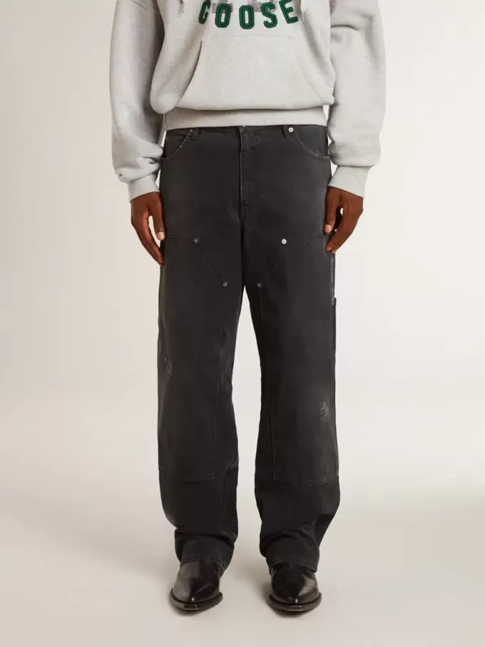 Herrenjeans aus schwarzem Baumwollstoff im Distressed-Look mit Aufnähern auf der Vorderseite Herrenjeans aus schwarzem Baumwollstoff im Distressed-Look mit Aufnähern auf der Vorderseite
