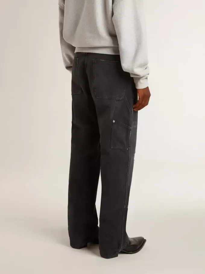 Herrenjeans aus schwarzem Baumwollstoff im Distressed-Look mit Aufnähern auf der Vorderseite Herrenjeans aus schwarzem Baumwollstoff im Distressed-Look mit Aufnähern auf der Vorderseite