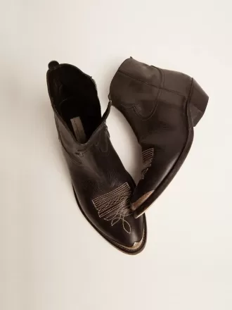 Junge Stiefeletten aus schwarzem Leder mit sandfarbener Stickerei