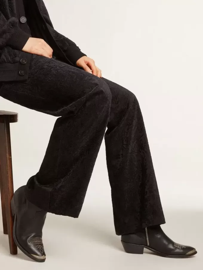 Junge Stiefeletten aus schwarzem Leder mit sandfarbener Stickerei