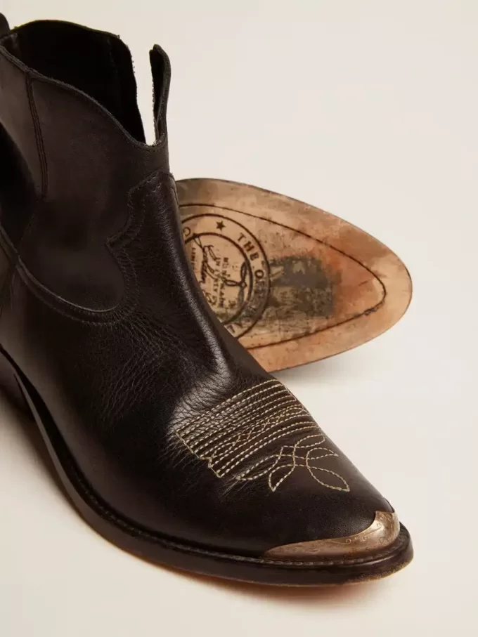 Junge Stiefeletten aus schwarzem Leder mit sandfarbener Stickerei