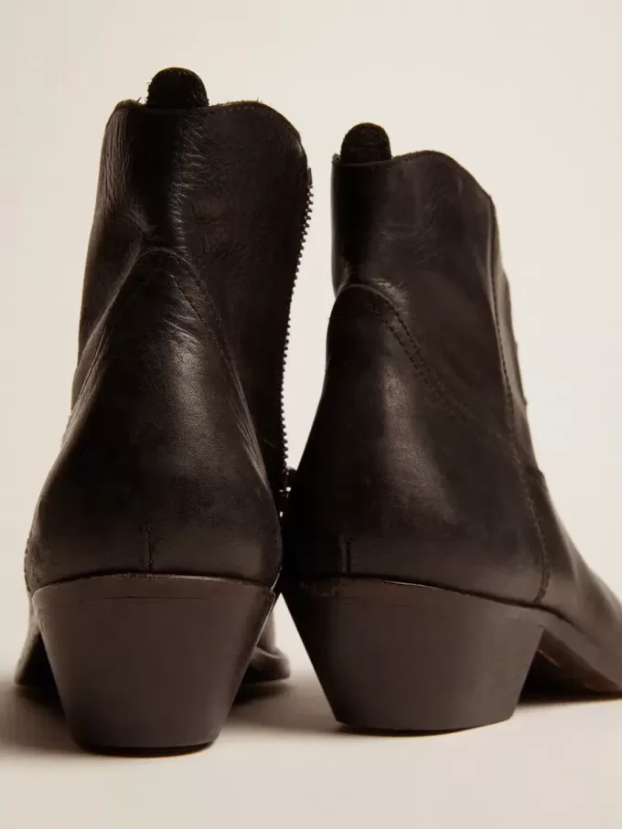 Junge Stiefeletten aus schwarzem Leder mit sandfarbener Stickerei