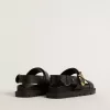 Lucy Sandale für Damen aus glänzendem schwarzem Leder mit goldener Metallschnalle Lucy Sandale für Damen aus glänzendem schwarzem Leder mit goldener Metallschnalle