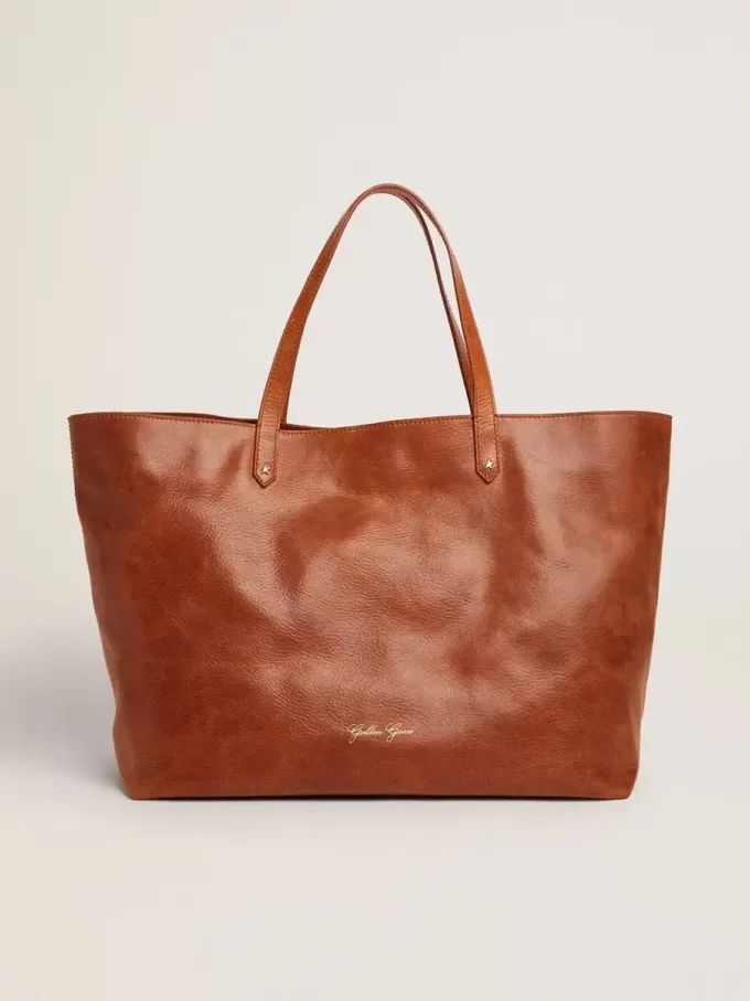 Pasadena-Tasche aus hellbraunem, glänzendem, gehämmertem Leder mit goldenem Logo auf der Vorderseite Pasadena-Tasche aus hellbraunem, glänzendem, gehämmertem Leder mit goldenem Logo auf der Vorderseite