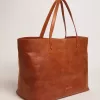 Pasadena-Tasche aus hellbraunem, glänzendem, gehämmertem Leder mit goldenem Logo auf der Vorderseite Pasadena-Tasche aus hellbraunem, glänzendem, gehämmertem Leder mit goldenem Logo auf der Vorderseite