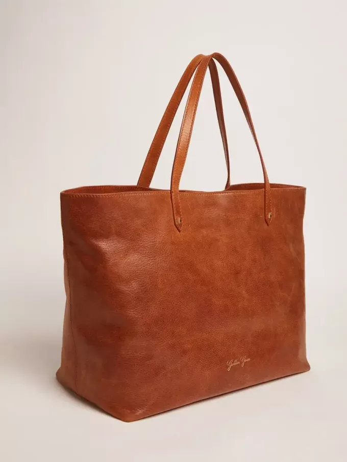 Pasadena-Tasche aus hellbraunem, glänzendem, gehämmertem Leder mit goldenem Logo auf der Vorderseite Pasadena-Tasche aus hellbraunem, glänzendem, gehämmertem Leder mit goldenem Logo auf der Vorderseite