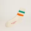Weiße Socken mit Distressed-Finish und grünen und orangefarbenen Streifen