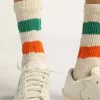 Weiße Socken mit Distressed-Finish und grünen und orangefarbenen Streifen