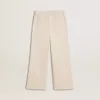 Weite, cremefarbene Mädchenhose mit Rippstrick und Stickerei